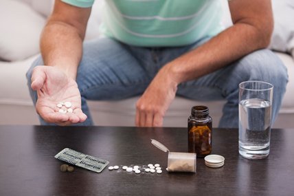 Man with his medicine laid out on coffee table